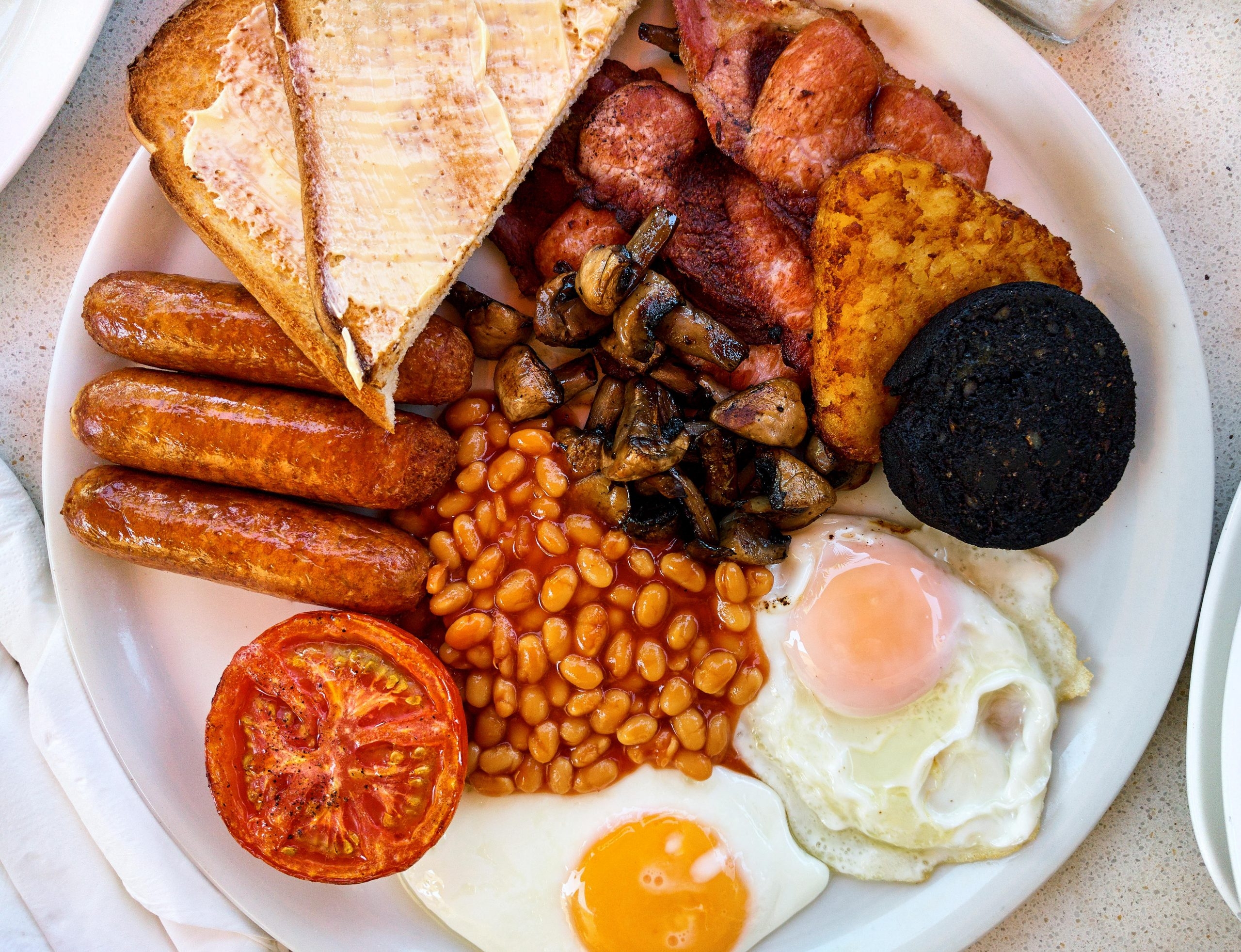 Traditional full english breakfast. Fried eggs, baked beans, bacon, sausages and toasts