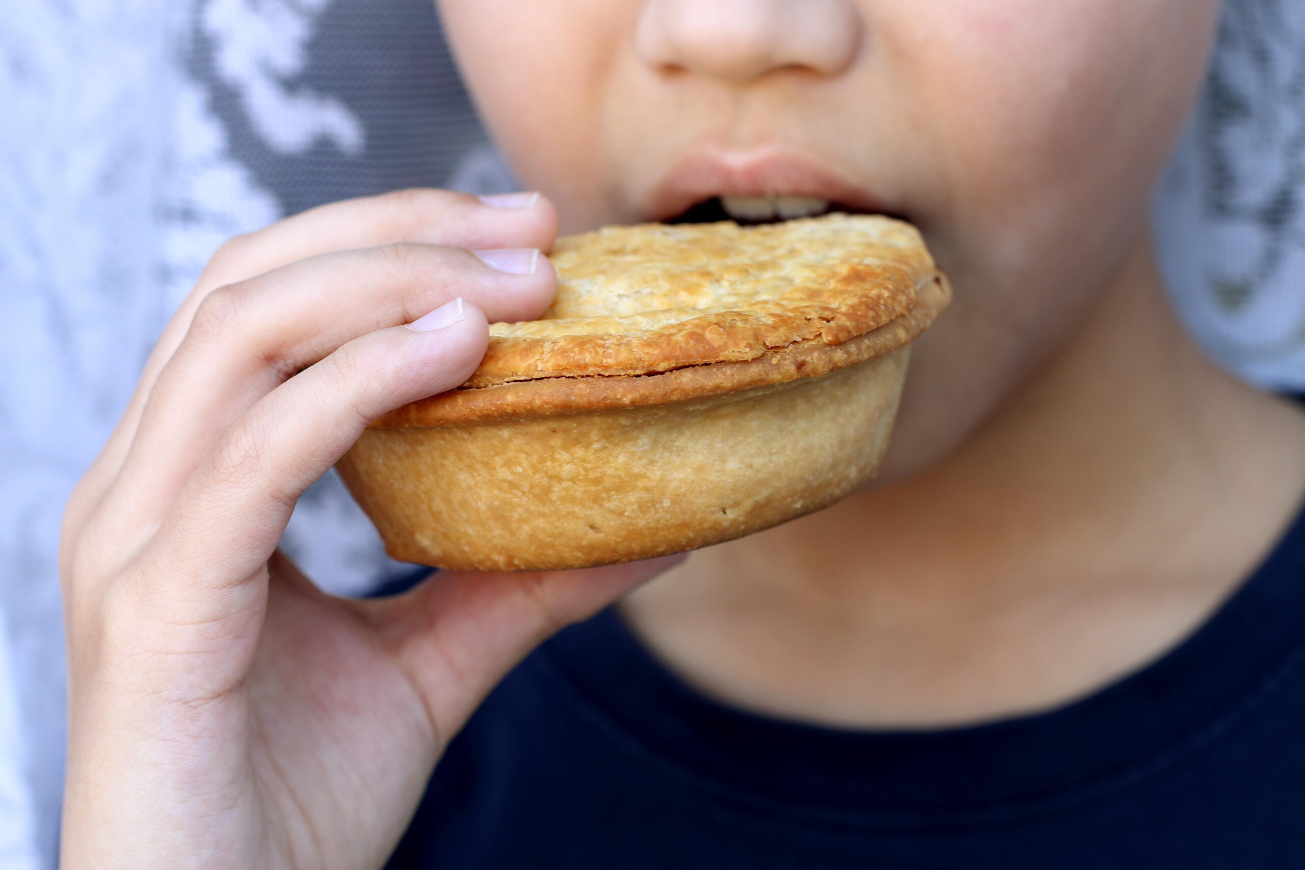 child eating meat pie